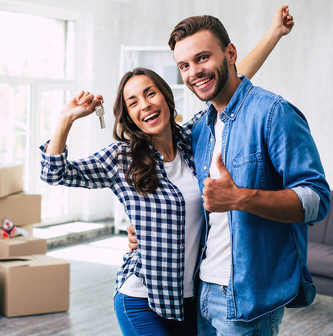 happy couple in a new home holding keys