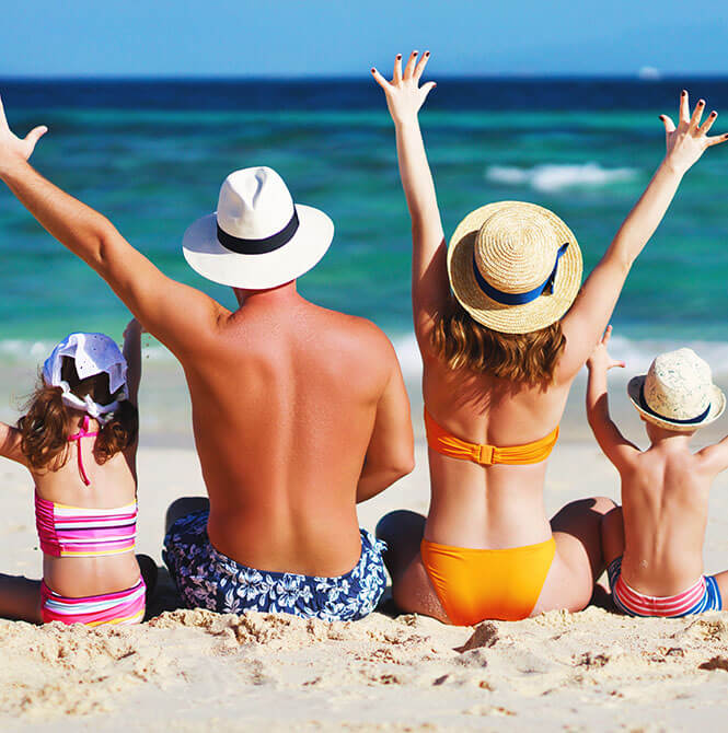 family sitting on the beach